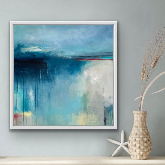 Framed abstract painting on a wall with a vase and starfish below.